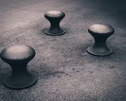 Fixed Positions Three identical forms hold their ground, spaced with intention on an otherwise indifferent surface.