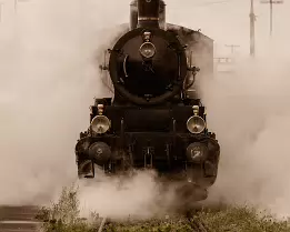 Vintage Power A vintage steam locomotive pushes forward through thick clouds of white steam.