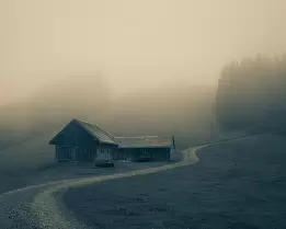 Winding Path Fog blankets a wooden hillside barn and a curving gravel path.