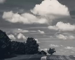 Cloudy Way A narrow rural road snakes uphill toward a lone barn under billowing clouds.